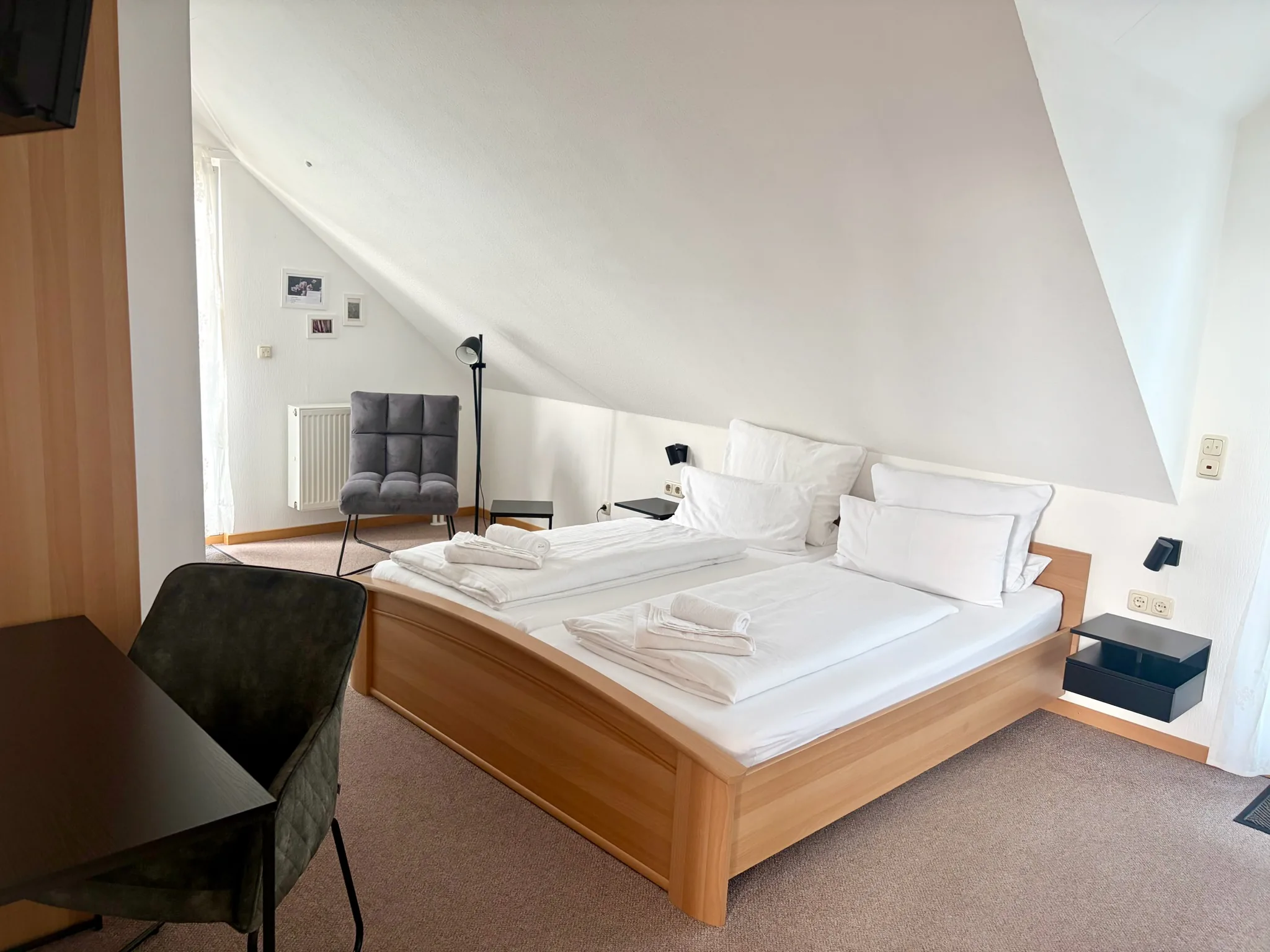 Zimmer Scheurebe Schlossblick – Doppelbett unter der Dachschräge mit Sessel und Flat-TV